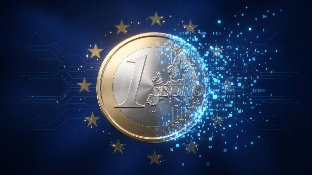 Eine Euro-Münze löst sich am Rand in blaue digitale Pixel auf, vor dunkelblauem Hintergrund mit goldenen EU-Sternen, als Sinnbild für den digitalen Euro