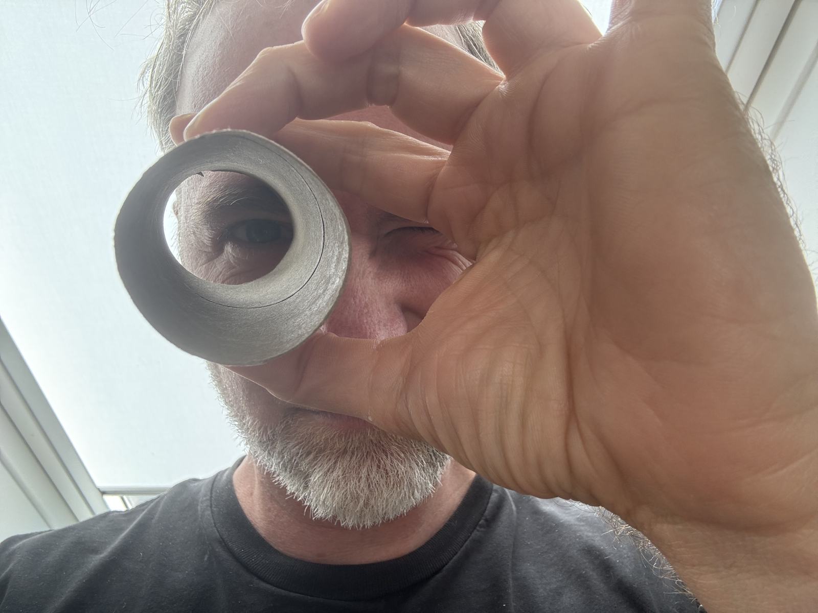 Tobi hält die Klopapierrolle in die Kamera, durch die er auf dem Beitragsbild blickt